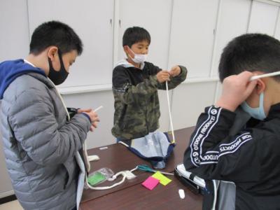 エプロンの肩ひもを通しています エプロンの肩ひもを通しています